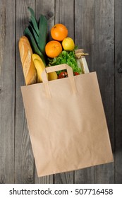 Various Food In Paper Bag On Wooden Background. Grocery Shopping Concept, Top View