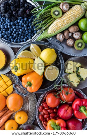 Foto Bild Bunter Obstteller als Blumenmuster angeordnet auf dunkler Platte mit leckerer Creme und Zutaten