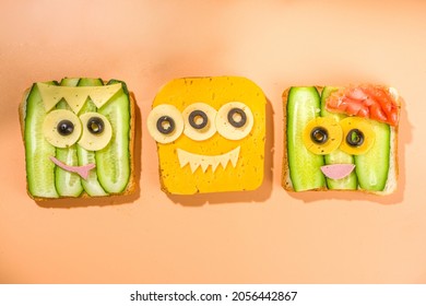 Various funny monster Halloween sandwiches. Set assortment creative breakfast snack toasts with cheese, Halloween kids party food, top view 