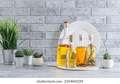 Various glass oil bottles for cooking on the kitchen countertop. Compact oil storage. Indoor flowers in pots. front view - Powered by Shutterstock