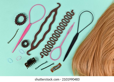 Various Hair Styling Tools Like Bun Maker, Braid Tool, Ponytail Style Maker, Hair Clip, Rubber Bands And Pins Next To Blond Hair