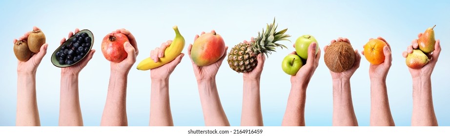 Various hands holding assorted fruits in a banner format.Banana, pineapple, apple and many other hands on diet background. - Shutterstock ID 2164916459