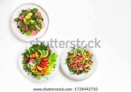 Various healthy salads of fresh vegetables,fruits and microgreens on table. Clean eating, lunch bowl. Top view. Concept taste of home meal.