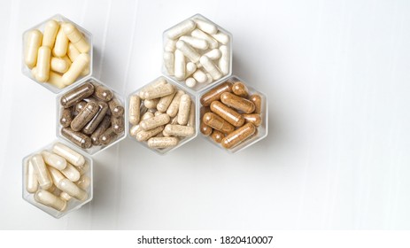 Various herbal and homeopathic medical capsules in hexagonal jars in the form of honeycomb - Shutterstock ID 1820410007