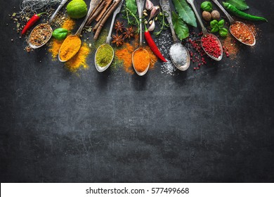 Various herbs and spices on black stone plate