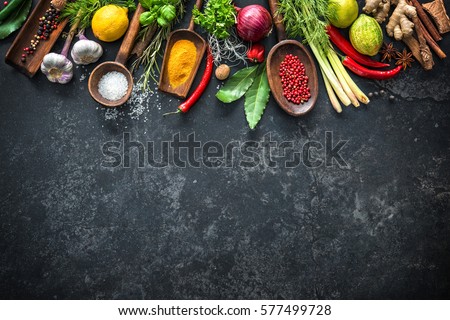Various herbs and spices on black stone plate