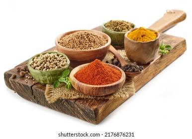 various herbs and spices on wooden board isolated on white background - Powered by Shutterstock