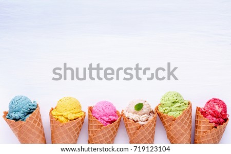 Various of ice cream flavor in cones blueberry ,strawberry ,pistachio ,almond ,orange and cherry setup on white wooden background . Summer and Sweet menu concept.