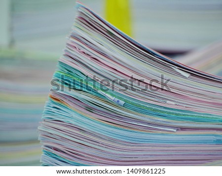 Various information documents, both studying and working  The documents are arranged together to form a high stack.
