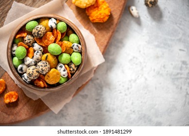 Various Japanese Snacks In A Wooden Bowl On A Grey Background. Free Space For Text. Rice Crackers With Wasabi And Nori, Peanuts With Sesame Seeds, And Other Snacks.  Mix Traditional Japanese Snack