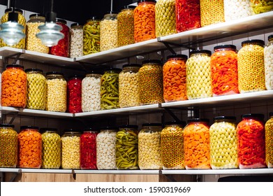 Various jars with Home Canning Fruits and Vegetables jam on glass shelves