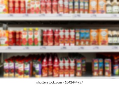 Various Juices On The Shelves In The Supermarket. Blurred. Front View.