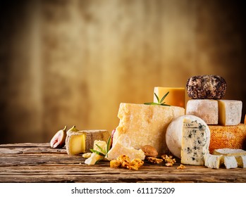 Various kind of cheese served on wooden table, traditional pieces of french and italy hand-made cheese. Copyspace for text