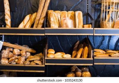 various kinds of bread on shelves in bakery shop - Shutterstock ID 1035243130