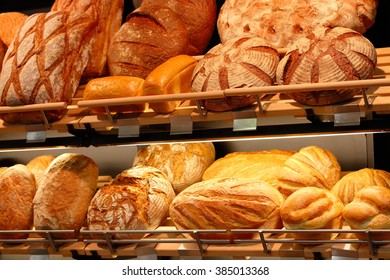 Various kinds of fresh baked artisan bread on the shelves in the bakeshop.