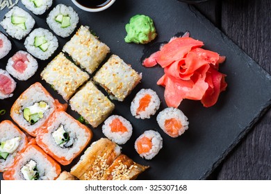 Various kinds of sushi served on black stone