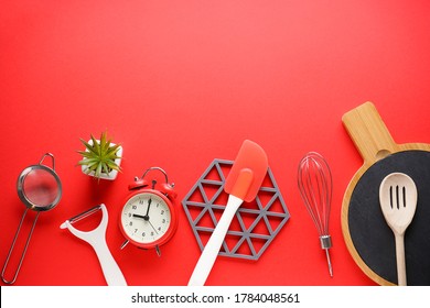 Various Kitchen Utensils On A Red Background With Space For Text, Flat Lay.