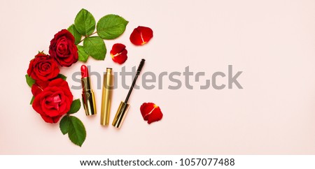 Various makeup products Red Lipstick Mascara with red roses on a pink background with copy space top view Flat Lay