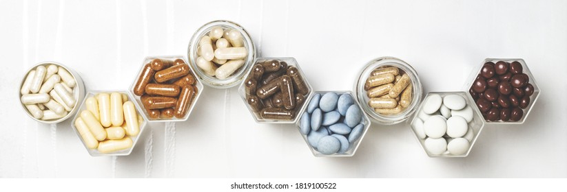 Various medical capsules and tablets in hexagonal jars in the form of honeycomb - Shutterstock ID 1819100522