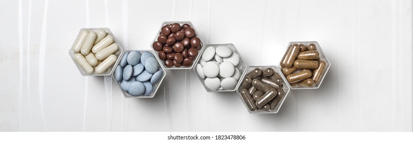 Various medical capsules and tablets in hexagonal jars in the form of honeycomb - Shutterstock ID 1823478806