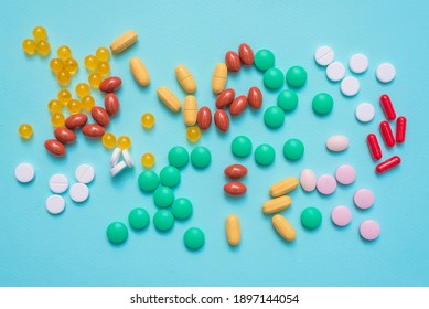 Various medical tablets on the blue flat lay background.