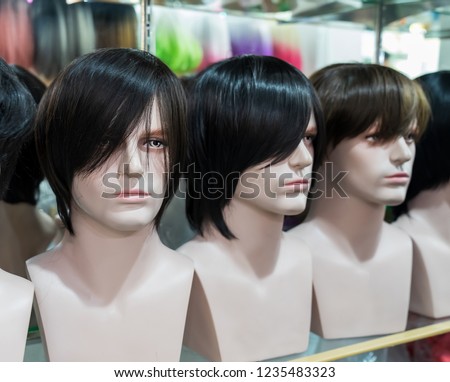 Various men's wigs Many styles in the wig shop. Modern fashion, beauty salon, hair design, bright hair color.
