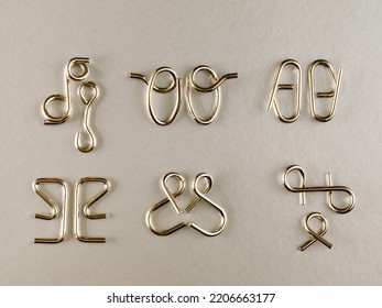 The Various Metal Wire Puzzle (puzzle Ring) On Grey Background. Top View Flat Lay. Brain Teaser.