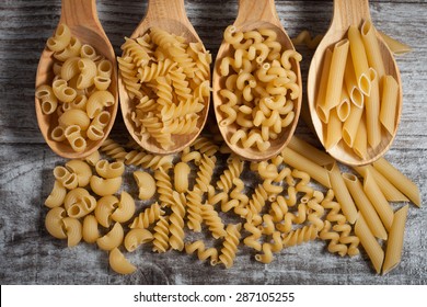 Various mix of pasta on wooden rustic background, sack and wooden spoons. Diet and food concept. - Shutterstock ID 287105255