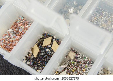 Various Nail Art Beads, Rhinestones And Accessories Neatly Organized In Clear Containers.