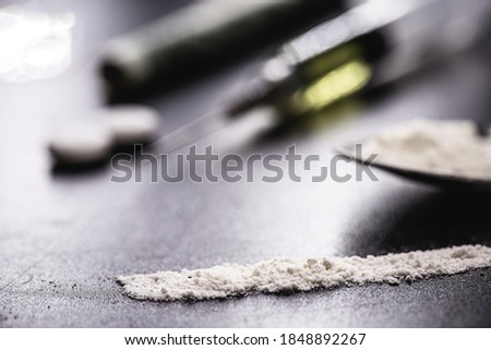 various narcotics on a dark table, consumption or purchase of illegal drugs, pills, cocaine and heroin