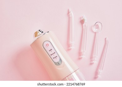 Various Nozzles For Cleaning Teeth With Water Jet And Dental Water Teeth Cleaner Water Flossing Oral Irrigator On Pink Background