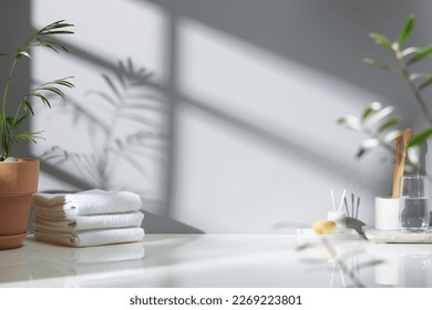 Various objects on a white tile background with warm sunlight shining through
					