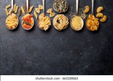 Various pasta on spoons over stone background. Top view with copy space - Powered by Shutterstock