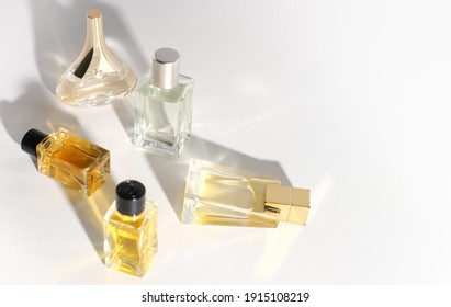 Various Perfume Bottles On A White Background. Travel Size Fragrance Bottles. Sample Mini Perfume For Women. Trendy Direct Light. 