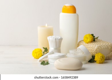 Various Personal Care Products. Soap, Cotton Pads, Washcloth, Sticks And Yellow Flowers On A White Background. Spa