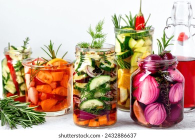 Various pickled vegetables in glass jars. Pickling of various vegetables. Pickled vegetables with herbs and spices on the table. The concept of fermented vegetarian food. - Powered by Shutterstock