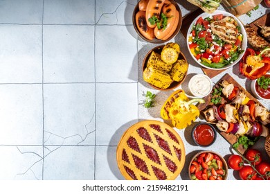 Various Picnic Barbeque Food And Drink Flatlay. Summer Bbq Picnic Food, Assorted Grilled Meats, Kebabs, Vegetable, Fruit Salad, Traditional Picnic Summer Pie Cake, Sandwiches, Top View Copy Space