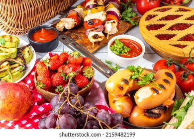 Various Picnic Barbeque Food And Drink Flatlay. Summer Bbq Picnic Food, Assorted Grilled Meats, Kebabs, Vegetable, Fruit Salad, Traditional Picnic Summer Pie Cake, Sandwiches, Top View Copy Space