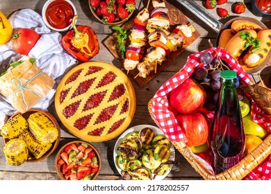 Various Picnic Barbeque Food And Drink Flatlay. Summer Bbq Picnic Food, Assorted Grilled Meats, Kebabs, Vegetable, Fruit Salad, Traditional Picnic Summer Pie Cake, Sandwiches, Top View Copy Space