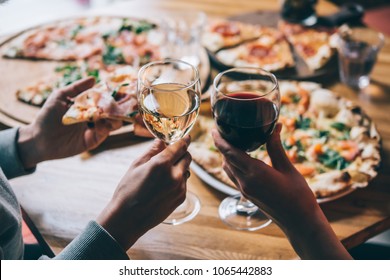 Various Pizzas And Glasses Of Wine Served For Dinner In A Restaurant.