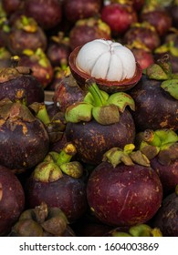 Various purple and fresh mangosteen, closed and peeled, filling the frame, close-up
