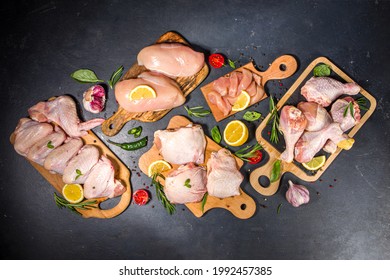 Various Raw Chicken Meat Portions. Set Of Uncooked Chicken Fillet, Thigh, Wings, Strips And Legs On Black Cooking Table Background With Spices 