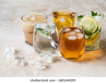 Various Refreshing Drinks In Glasses With Ice. Apple Juice, Homemade Lemonade, Iced Coffee, Iced Fruit Tea And Sparkling Water On Beige Background. Copy Space