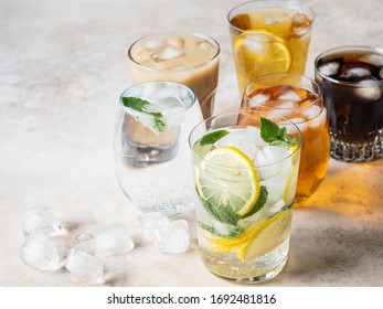 Various Refreshing Drinks In Glasses With Ice. Apple Juice, Cola, Homemade Lemonade, Iced Coffee, Iced Fruit Tea And Sparkling Water On Beige Background. Copy Space