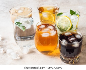 Various Refreshing Drinks In Glasses With Ice. Apple Juice, Cola, Homemade Lemonade, Iced Coffee, Iced Fruit Tea And Sparkling Water On Beige Background. Copy Space