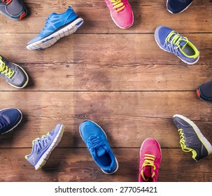 Various Running Shoes Laid On A Wooden Floor Background