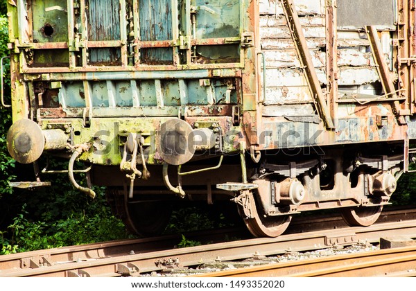 Various rusted wagons and train on the tracks at\
the lost railway\
station
