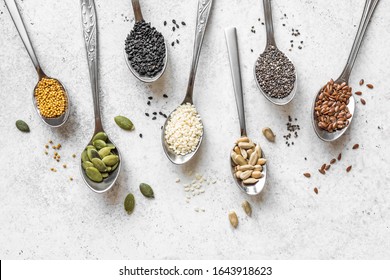 Various Seeds Assortment on white background. Set of  sesame seeds, flax seed, sunflower seeds, pumpkin seed, chia, hemp seeds in spoons, healthy food ingredients, top view, copy space. - Powered by Shutterstock