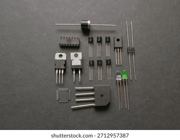 Various semiconductor components on a black. Transistors, voltage regulators, diodes.