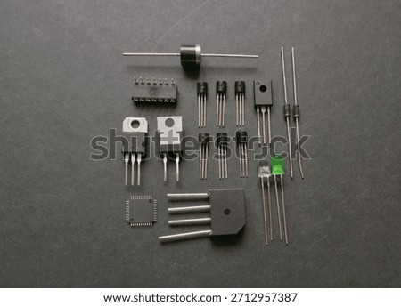 Various semiconductor components on a black. Transistors, voltage regulators, diodes.